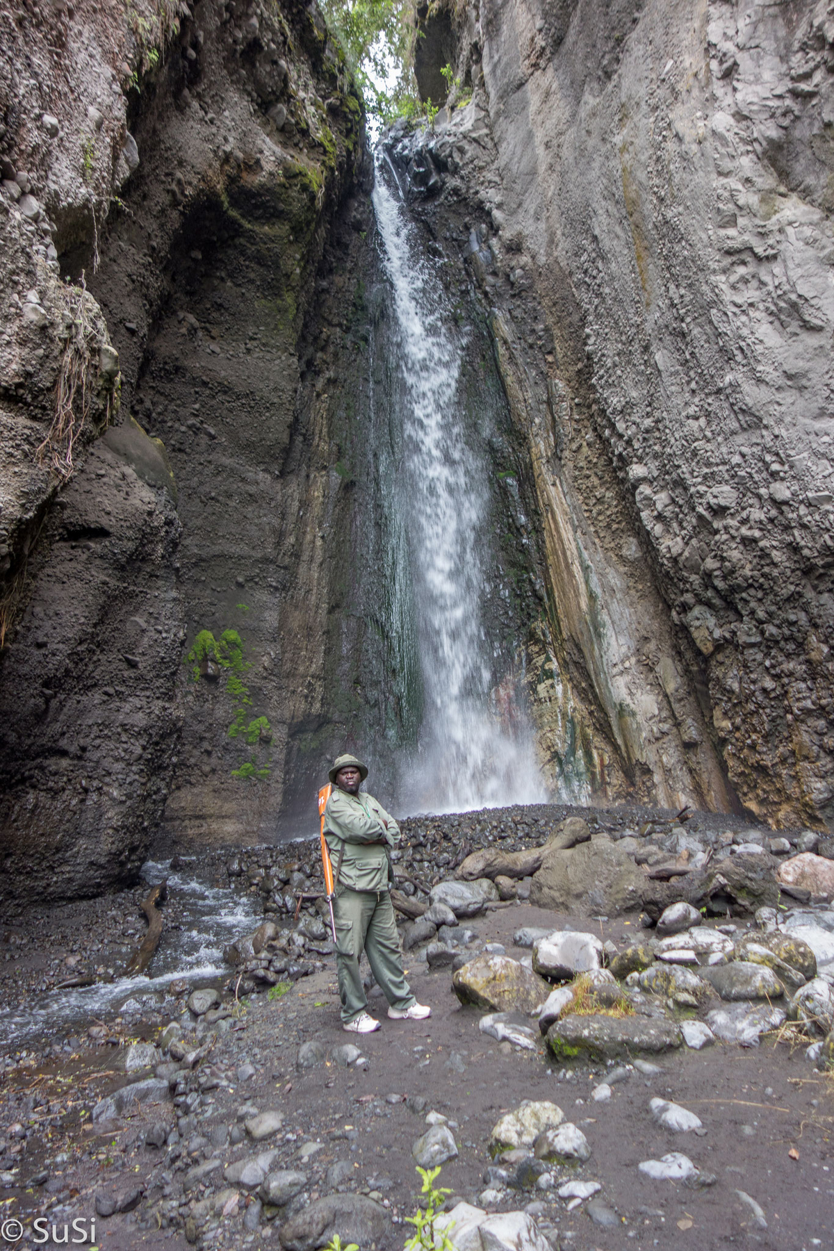 Ranger mit Gewehr vorm Tulusia Wasserfall